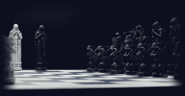 The carved black and white armies facing each other across the board